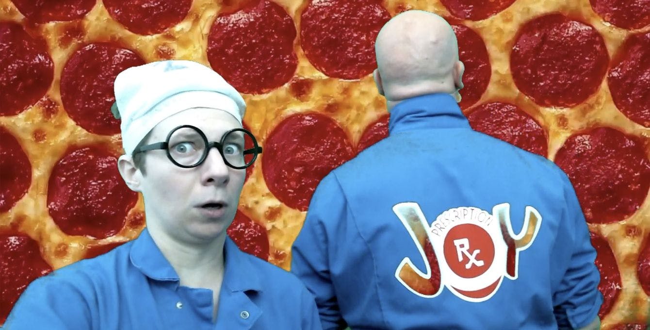 Two clowns standing in front of a pepperoni pizza close-up