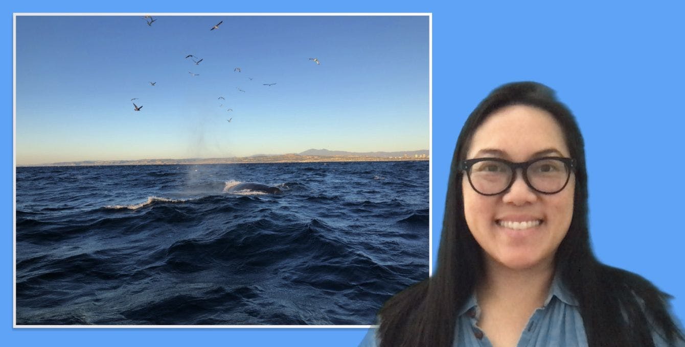 Woman smiling in front of a picture of the ocean