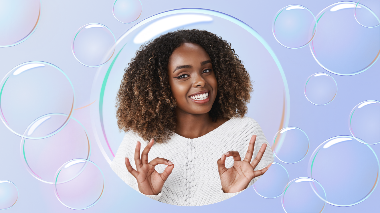 One person in a bubble doing "okay" signs with their hands against light purple background with iridescent bubbles