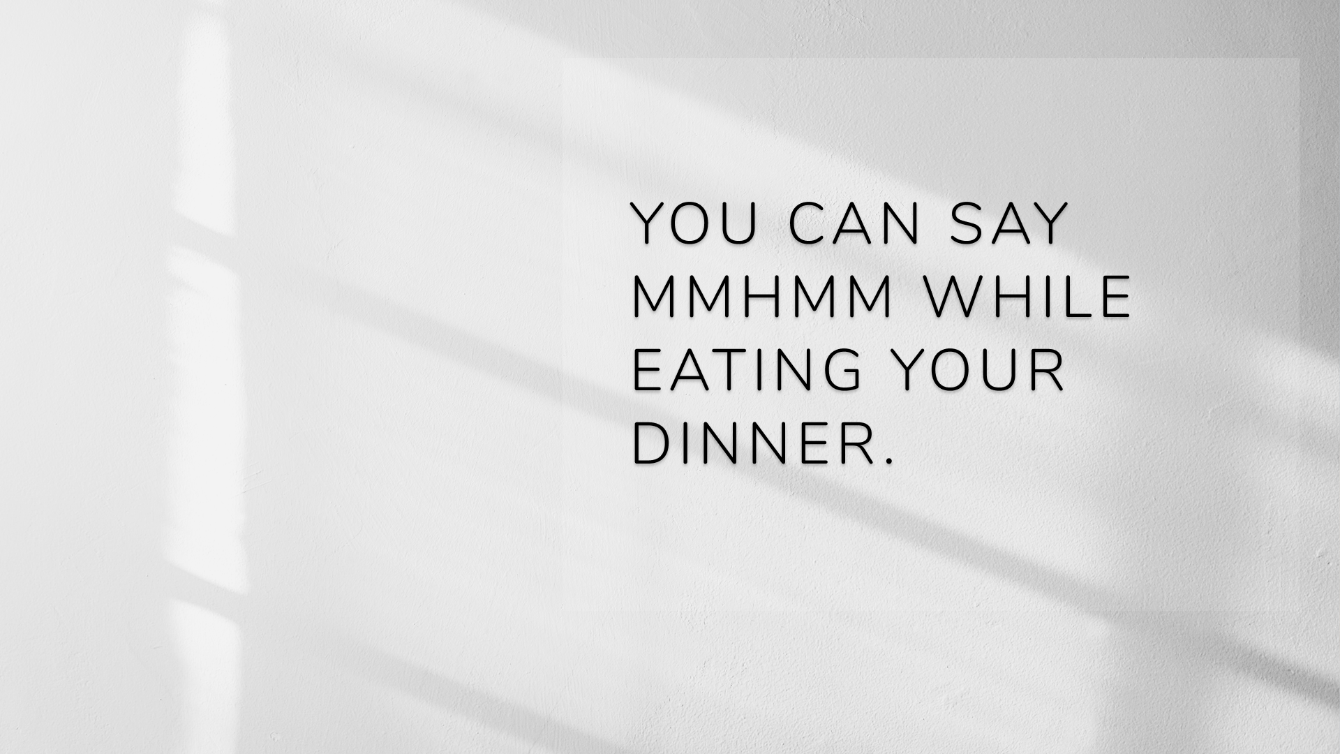 「You can say mmhmm while eating your dinner.」と書かれたスライドと太陽光が当たる白い壁
