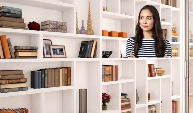 Person with long hair in white shelves room
